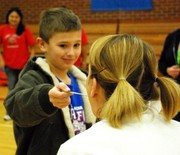 Gunner Stapleton feeding Mrs. McVey baby food as he was the winning fund raiser for Jump rope for heart.