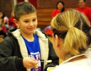 Gunner Stapleton feeding Mrs. McVey baby food as he was the winning fund raiser for Jump rope for heart.
